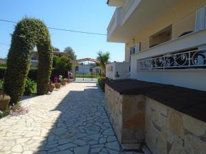 a stone walkway in front of a house at Finikes Studios in Oreoi