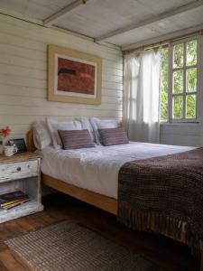 a bedroom with a large bed and a window at Pacheco Farmhouse - Intag Valley in Peñaherrera
