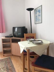 ヘーヴィーズにあるFranciska Apartmanのテーブル、椅子、テーブル、テレビ付