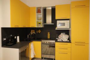 eine Küche mit gelben Schränken und einer Mikrowelle in der Unterkunft Am Liv' (mi alzo) in Bologna