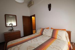 ein Schlafzimmer mit einem Bett mit einer Kommode und einem Spiegel in der Unterkunft Am Liv' (mi alzo) in Bologna