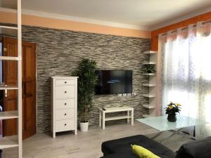 a living room with a tv on a brick wall at Vivienda Sara in Valle Gran Rey