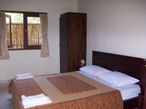 a bedroom with a large bed with two pillows at Petit Boo Amed in Amed