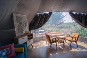 a room with a tent with a table and chairs at Glamping Podgrodzie in Nowe Warpno