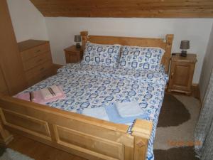 a bedroom with a wooden bed with blue and white sheets at Wolf Apartment in Žabljak