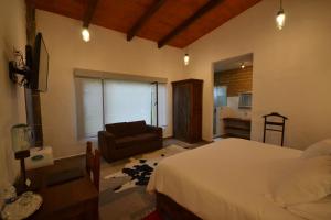 a bedroom with a bed and a couch in a room at Rústika SPA Hotel Boutique in Tepoztlán