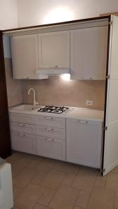 a kitchen with white cabinets and a stove top oven at Casa Ugolini since 1857 in Montescudo