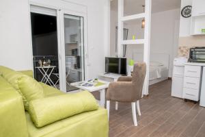 a living room with a yellow couch and a television at Apartments Tina in Utjeha
