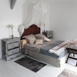 a bedroom with a bed and two night stands at Maison Lalanne in Castelnau-Chalosse