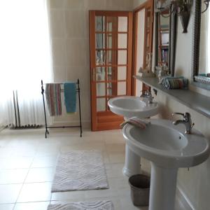 La salle de bains est pourvue de 2 lavabos et d'un miroir. dans l'établissement Maison Lalanne, à Castelnau-Chalosse