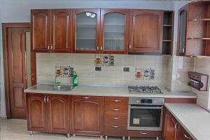 a kitchen with wooden cabinets and a stove top oven at Popasul Călătorului in Moisei