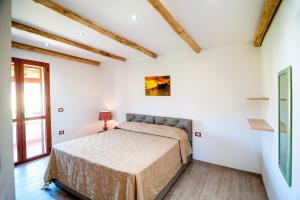 een slaapkamer met een bed en een raam bij Residence Tanaunella in Budoni