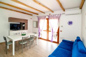 a living room with a blue couch and a table at Residence Tanaunella in Budoni
