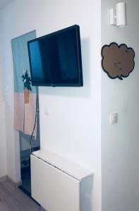 een flatscreen-tv op de top van een witte dressoir bij ★★ Studio Coeur Toulouse, Saint Georges, Capitole ★★ in Toulouse