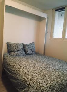 een bed met 2 kussens in een kamer met een raam bij ★★ Studio Coeur Toulouse, Saint Georges, Capitole ★★ in Toulouse