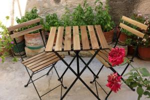 ノートにあるCasa vacanze Cortile Baroccoの木製のピクニックテーブルと花の横のベンチ2つ