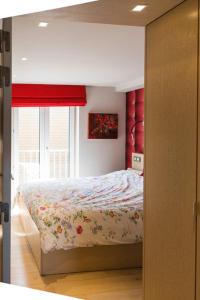 1 dormitorio con 1 cama con colcha de flores y ventana en Residentie New Sight en Knokke-Heist
