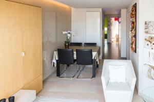 a dining room with a table and black chairs at Residentie New Sight in Knokke-Heist