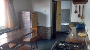 a kitchen with a wooden table and a stove at Casa El Mortero in Cafayate