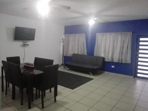 uma sala de estar com uma mesa e um sofá em MV Suites Suc. Capilla em Monterrey