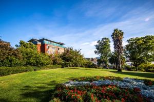a park with flowers and a building in the background at Salamanca Suites in Hobart
