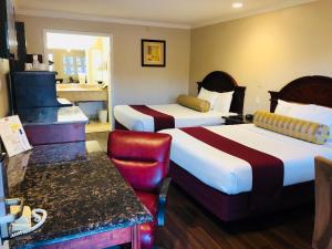 Un pat sau paturi într-o cameră la Dynasty Suites Hotel
