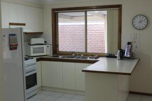 a kitchen with a sink and a clock on the wall at Australian Home Away @ Doncaster Anderson Creek 2 in Doncaster East