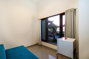a room with a large window and a blue couch at Dodol Lembongan Cliff Sunset in Nusa Lembongan