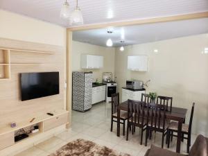 a kitchen and dining room with a table and chairs at Felipe Family Houses - Casas de temporada in Foz do Iguaçu