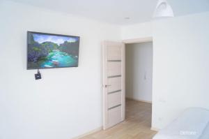 オクチャブリスキーにあるApartments on Sadovoe Koltso2のベッドルームに薄型テレビが掛けられています。