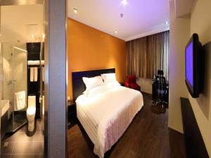 Habitación de hotel con cama y TV en 桔子水晶苏州观前街酒店, en Suzhou