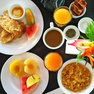 a table with plates of breakfast foods and drinks at The Pearl South Pacific Resort, Spa & Golf Course in Pacific Harbour