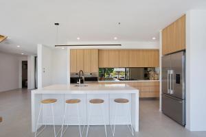 una cocina con una isla blanca con taburetes en Key West, en Gold Coast