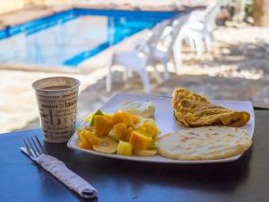 a plate of food with fruit and bread on a table at Hostel Nirvana San Gil in San Gil