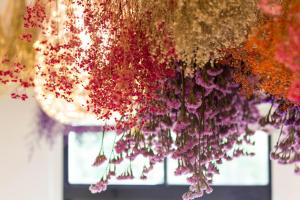 a bunch of flowers hanging from a ceiling at Meizhou Hot Spring Hotel溫泉商旅 in Jiaoxi