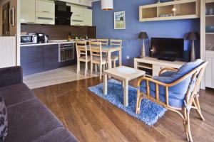a living room with a couch and a table and a kitchen at Klif Residence in Władysławowo