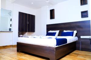 a bedroom with a large bed with blue and white pillows at Hotel Alka Residency in Thane