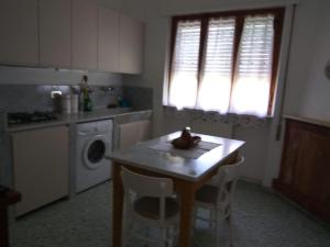 een keuken met een tafel en een wasmachine bij Casa del Nonno in Pietrasanta