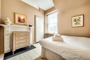 a bedroom with a bed and a dresser and a window at JOIVY Famous St Mary's Street Old Town Apartment in Edinburgh