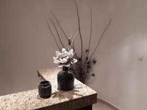 un vase avec des fleurs assis sur une table dans l'établissement Achillion, à Paralia Katerinis