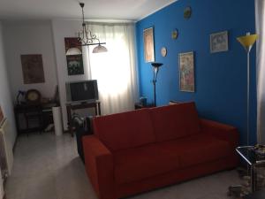 ein Wohnzimmer mit einem roten Sofa und einer blauen Wand in der Unterkunft Villa Agata in San Pietro Clarenza