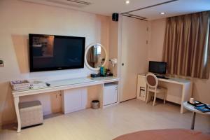 Pokój z biurkiem i dużym telewizorem na ścianie w obiekcie Hotel Diamant w Seulu