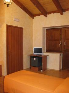 a bedroom with a bed and a desk with a computer on it at B&B COLLE DI CONDRO in Serrastretta