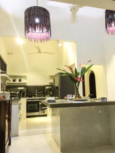 a large kitchen with a counter with flowers on it at Temple House Villa in Hikkaduwa