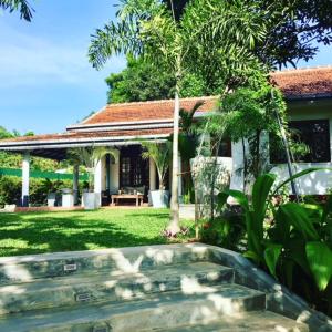 a house with a gazebo in a yard at Temple House Villa in Hikkaduwa
