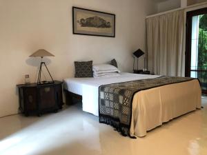 ein Schlafzimmer mit einem Bett und einer Lampe auf einem Tisch in der Unterkunft Geoffrey Bawa's Home Number 11 in Colombo