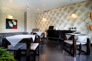 a restaurant with tables and a piano on the wall at The Saneer Jaipur in Jaipur