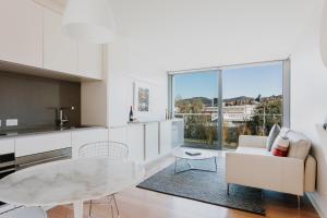 cocina y sala de estar con mesa y sofá en Quarry House Luxury Retreat, en Hobart