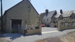 un edificio con una recinzione bianca di fronte di gîte de la Girouette a Englesqueville-la-Percée