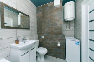 bagno con lavandino, servizi igienici e specchio di Sofii Rusovoi 3v a Kiev
